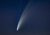Eine Nahaufnahme des Kometen NEOWISE (C/2020 F3) in der Nacht vom 14. auf den 15. Juli 2020 mit einem 135-mm-Teleobjektiv, und etwas beschnitten. Das Feld ist jedoch etwa 10° hoch und der weiße Staub und die blauen Ionenschweife erstrecken sich über das gesamte Bild und darüber hinaus. Ein Teil der Bänderstruktur im Staubschweif ist sichtbar.