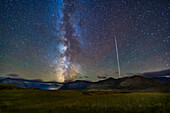 The northern summer Milky Way setting over the mountains of Waterton Lakes National Park, Alberta, Canada, with the Space Station rising at right, then fading into sunset, in a trail from the series of long exposures. This is from the Bison Compound viewpoint looking south and southwest, on September 21, 2019, in frames taken as part of a time-lapse.
