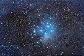 The Pleiades star cluster, Messier 45, amid the faint and dusty nebulosity that surrounds it. The stars of the Pleiades are passing through the dust clouds in Taurus and are lighting them up as examples of reflection nebulas.