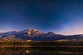 The stars of the Big Dipper over the iconic peak of Pyramid Mountain from Pyramid Island, a popular location in Jasper National Park, Alberta, for nightscape and aurora photography. This was on a very clear night in mid-October, 2022, with many aspen stands still in full autumn colour. The images for this scene were shot at moonrise, with the waning gibbous Moon off frame at right lighting the sky blue and landscape with warm alpenglow moonlight. As bonus, a short bright meteor and its orange "smoke" trail appeared on the sky exposures. I shot this during the first weekend of the 2022 Jasper D