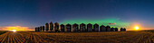 A faint aurora glowing over the harvest in progress this night, with trucks and combines lighting the field at left, and the Harvest Moon itself - actually three days after Full Moon - lighting the scene at right. The combination of lighting from manmade and natural sources makes for an interesting illumination on the grain bins. The Big Dipper is left of centre, pointing down to Arcturus at far left, and Perseus is at right. The Pleiades are just rising over the far right bins.