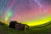 A circumpolar star trail composite, shot at the old Larson Ranch site in the Frenchman Valley at Grasslands National Park, Saskatchewan, August 27/28, 2014. The pioneer cabin was the home of the legendary western author and movie star Will James, born Ernest Dufault in Quebec. He lived in this cabin when he worked the ranches in the area. The aurora was excellent this night. This is a stack of 20 1-minute exposures at ISO 2500 with the 15mm full-frame fish-eye lens at f/3.2 and the Canon 6D. The foreground and point-like stars are from the first frame in the series.