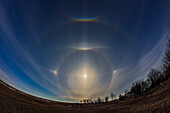 A complex of halo phenomena on the evening of April 15, 2022, Good Friday of the 2022 Easter weekend, around the almost Full Moon. Ice crystals in the high cloud created the halos and arcs, set in the spring night sky, with the Big Dipper at top, Arcturus to the left, and Regulus and Leo at right. The colours of the arcs and sundogs were just visible to the unaided eye.