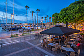 Blick auf Cafés und Boote im Hafen von Kos in der Abenddämmerung, Kos Stadt, Kos, Dodekanes, Griechische Inseln, Griechenland, Europa