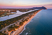 Luftaufnahme des Sees und des Strandes von Sabaudia mit dem bewaldeten Berg Circeo im Hintergrund in der Abenddämmerung, Sabaudia, Tyrrhenisches Meer, Provinz Latina, Latium (Lazio), Italien, Europa