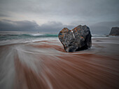 Langzeitbelichtung des fließenden Meeres und eines herzförmigen Felsens am Strand von Portizuelo, Asturien, Spanien, Europa