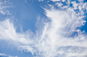 Weiße Zirruswolken vor blauem Himmel