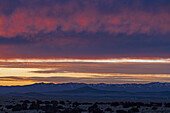 USA, New Mexico, Santa Fe, Dramatic sunset sky over Cerrillos Hills State Park desert landscape