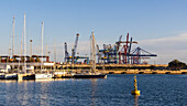 Spanien, Valencia, Segelboote im Yachthafen mit Hafenkränen im Hintergrund