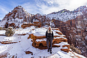 USA, Utah, Springdale, Zion National Park, Ältere Frau beim Wandern in den Bergen im Winter