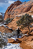 USA, Utah, Springdale, Zion National Park, Ältere Frau beim Wandern in den Bergen im Winter