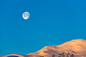 USA, Idaho, Sun Valley, Vollmond über schneebedeckten Hügeln