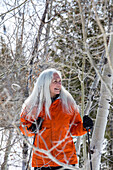 Lächelnde Seniorin beim Schneeschuhwandern in der Natur