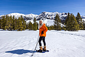 USA, Idaho, Ketchum, Lächelnde Frau beim Schneeschuhwandern in den Bergen
