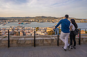 Couple with elevated view of harbour, Dalt Vila district and city defence walls, UNESCO World Heritage Site, Ibiza Town, Eivissa, Balearic Islands, Spain, Mediterranean, Europe