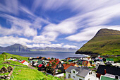Flauschige Wolken am Sommerhimmel über den traditionellen Häusern von Gjogv, Eysturoy Island, Färöer Inseln, Dänemark, Europa
