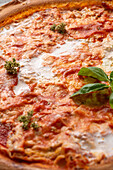 Thin pizza crust with tomato sauce and soft cheese