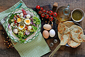 Mixed salad with boiled eggs, mozzarella balls and pesto
