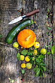 Still life with Hokkaido squash, zucchini, and yellow plums