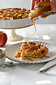 Homemade apple pie with lattice top, served with caramel sauce