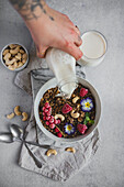 Pouring Cashew Milk over Granola with Fruit