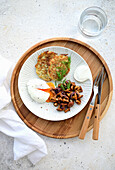 Potato and zucchini pancakes, sour cream, poached egg, and fried chanterelles with onions