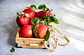 Wooden box with red apples on concrete table