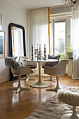 Essbereich mit weißem Tisch, weißen Stühlen und Spiegel im Altbauzimmer