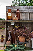 Rustikale Gartendekoration mit antiken Flaschen und Pflanzen