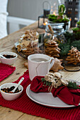 Weihnachtliches Frühstück mit Lebkuchen und Tee auf rotem, gehäkeltem Tischset