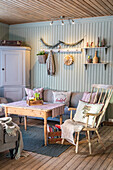 Rustic living room with wooden furniture and pastel green wall panelling