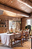 Festively laid Christmas table in rustic wooden hut, natural materials