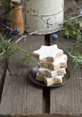 Wooden table with cinnamon stars on a small plate