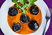 Black squid ravioli with tomato sauce