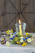 Lantern with candle in a wreath of muscari, primroses (Primula veris), primroses and hay