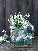 Strauß aus Schneeglöckchen (Galanthus) und altes Besteck im Bügelglas und Minivasen