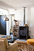 Living room with cast-iron stove, shelf and patterned carpet