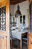 Rustic dining area with wooden table and pendant lights in the veranda