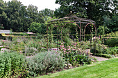 Metal gazebo with wildflower bed in the summer garden