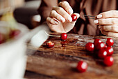Pitting red cherries with a hairpin