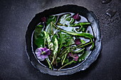 Wild herbs in a bowl with water