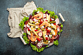 Fiambre, salad of Guatemala, Mexico and Latin America, on large plate top view white wooden background top view with cold cuts, shrimps. Festive dish for All Saints Day (Day Of The Dead) celebration.