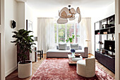 Modern living room with unusual pendant light and pink carpet