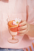 Glass with water and grapefruit slices, decorated with blossom