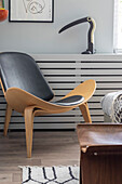 Black designer chair in front of white wall panelling