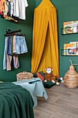 Children's room with green-painted walls, yellow canopy and plush toy monkey