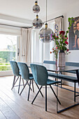 Dining room with blue chairs, glass pendant lights and large window