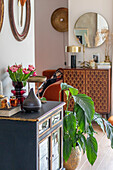 Console with tulips (Tulipa) and houseplant in modern hallway