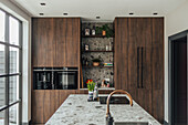 Modern kitchen with dark wooden cabinets and stone worktop