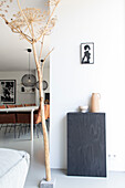 Giant dry hogweed plant next to modern dining area with leather armchairs